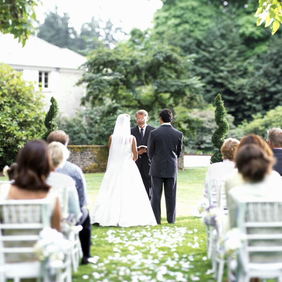 A bride and groom getting married at an outdoor wedding during summertime.